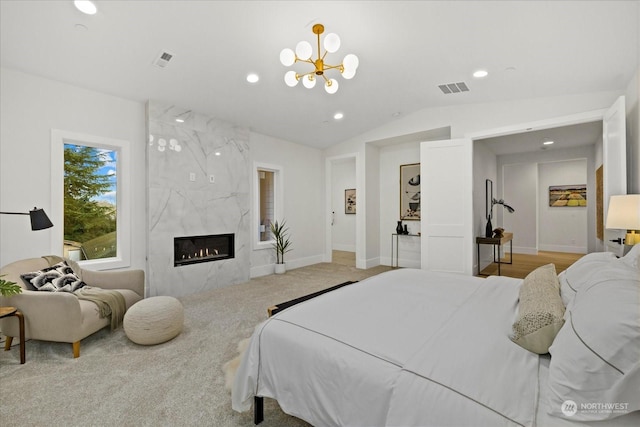 bedroom with a fireplace, light colored carpet, lofted ceiling, and an inviting chandelier