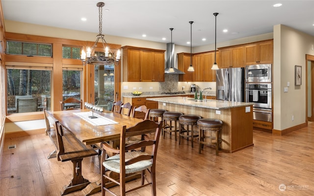 dining room with light hardwood / wood-style floors, an inviting chandelier, and sink