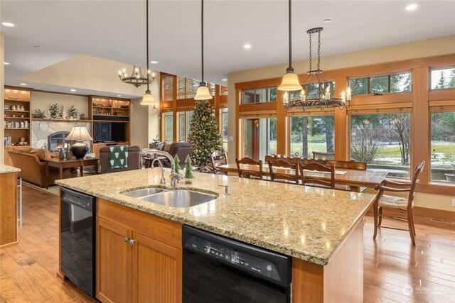 kitchen featuring a center island with sink, dishwasher, and hanging light fixtures