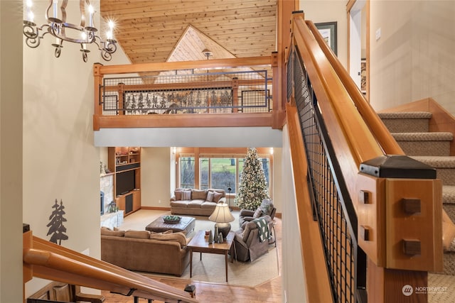 staircase with high vaulted ceiling, wooden ceiling, and an inviting chandelier