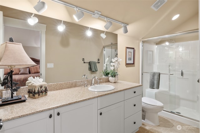 bathroom with vanity, a shower with shower door, vaulted ceiling, and toilet