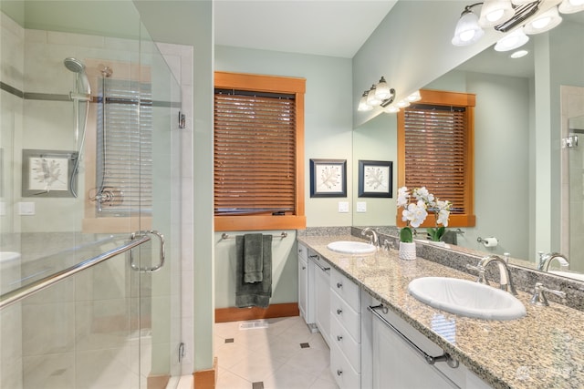 full bathroom featuring a stall shower, tile patterned flooring, a sink, and double vanity