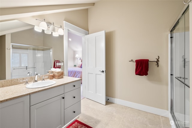 ensuite bathroom with connected bathroom, vanity, baseboards, vaulted ceiling, and a stall shower