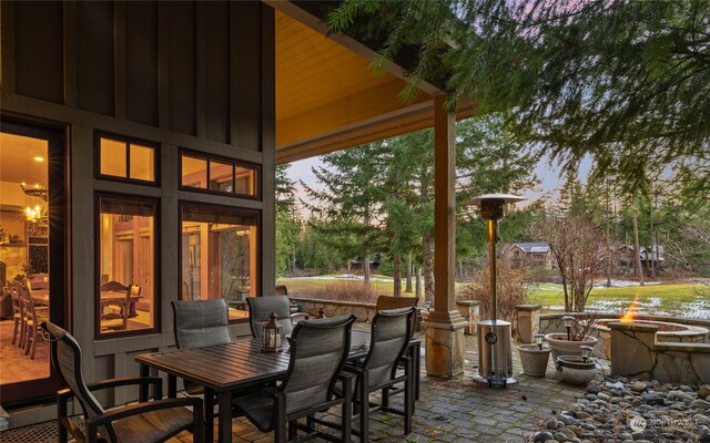 patio terrace at dusk featuring an outdoor fire pit