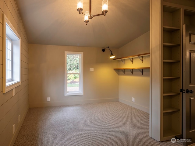 carpeted empty room featuring vaulted ceiling