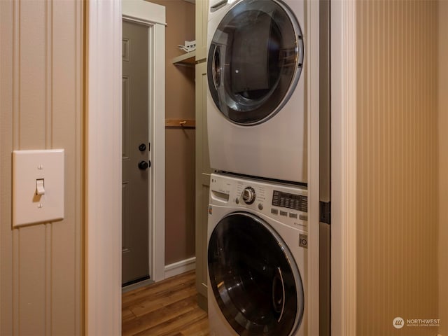 washroom with stacked washer / drying machine and light hardwood / wood-style floors