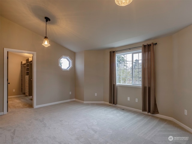 carpeted empty room with lofted ceiling