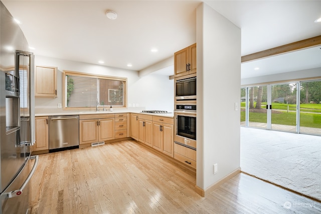 kitchen with light hardwood / wood-style floors, light brown cabinetry, sink, and appliances with stainless steel finishes