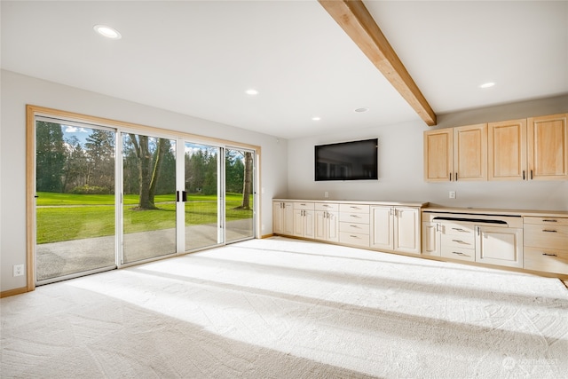 unfurnished living room featuring beam ceiling and light colored carpet