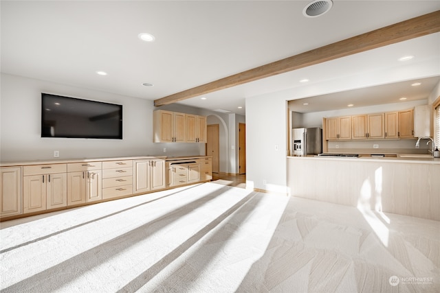 living room featuring beam ceiling, light colored carpet, and sink