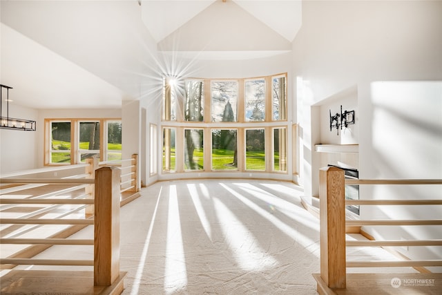 interior space featuring an inviting chandelier, carpet floors, and high vaulted ceiling