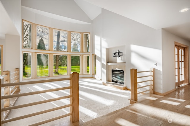 unfurnished living room with hardwood / wood-style flooring and high vaulted ceiling