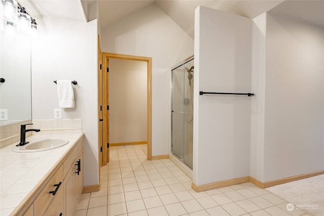 bathroom featuring tile patterned floors, vanity, lofted ceiling, and walk in shower