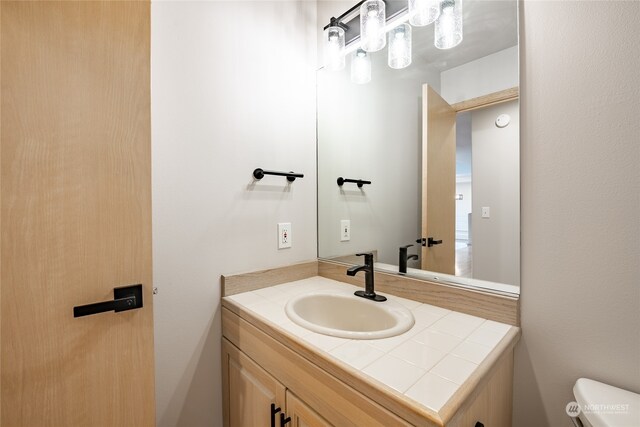 bathroom featuring vanity and toilet