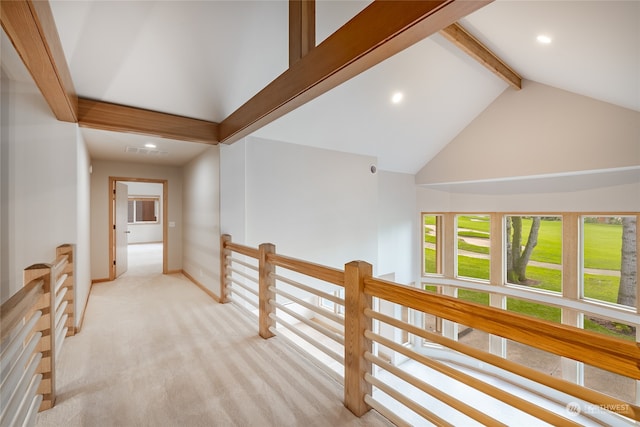 corridor featuring beamed ceiling, light carpet, and high vaulted ceiling