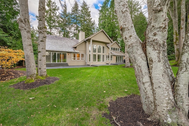 rear view of house featuring a yard