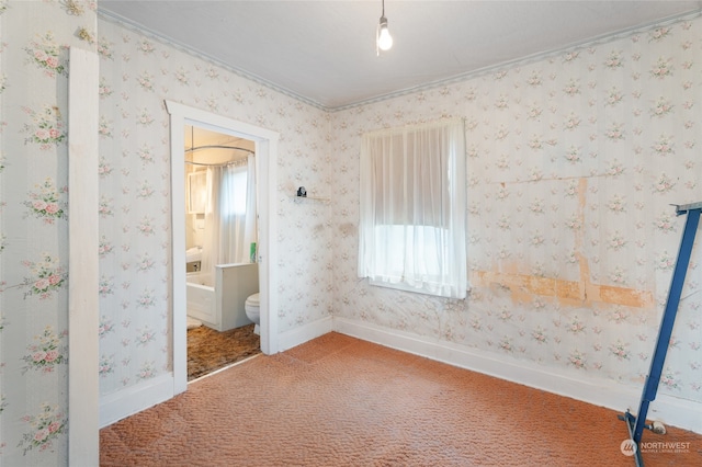 unfurnished bedroom featuring carpet flooring, ensuite bathroom, and crown molding