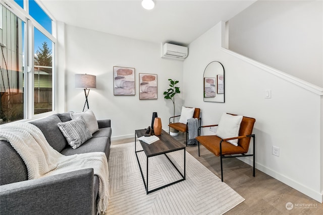 living room featuring a wall mounted air conditioner and light hardwood / wood-style flooring