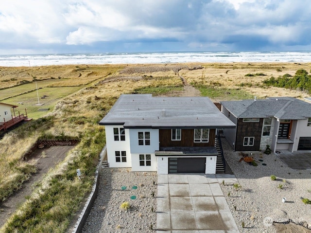 birds eye view of property with a water view and a beach view