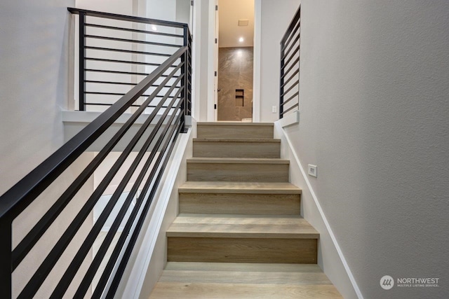 staircase with hardwood / wood-style floors