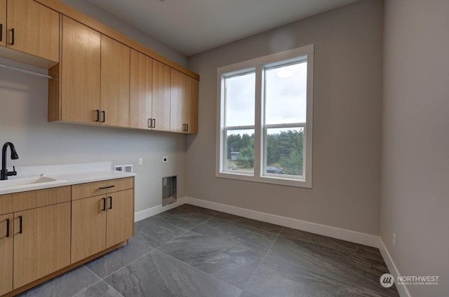 laundry area with hookup for an electric dryer, cabinets, sink, and washer hookup