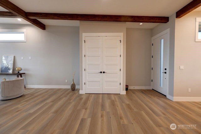 entrance foyer featuring beamed ceiling and light hardwood / wood-style flooring