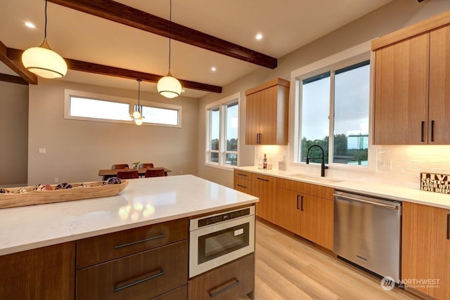 kitchen with hanging light fixtures, beamed ceiling, stainless steel appliances, and sink