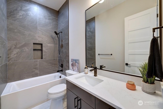 full bathroom with vanity, tiled shower / bath combo, and toilet