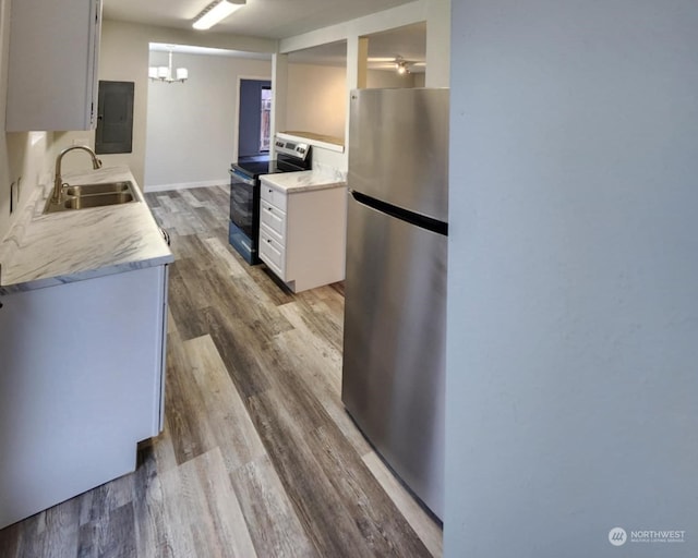 kitchen featuring white cabinets, sink, wood-type flooring, and stainless steel appliances