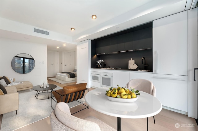 living room with sink and light hardwood / wood-style floors