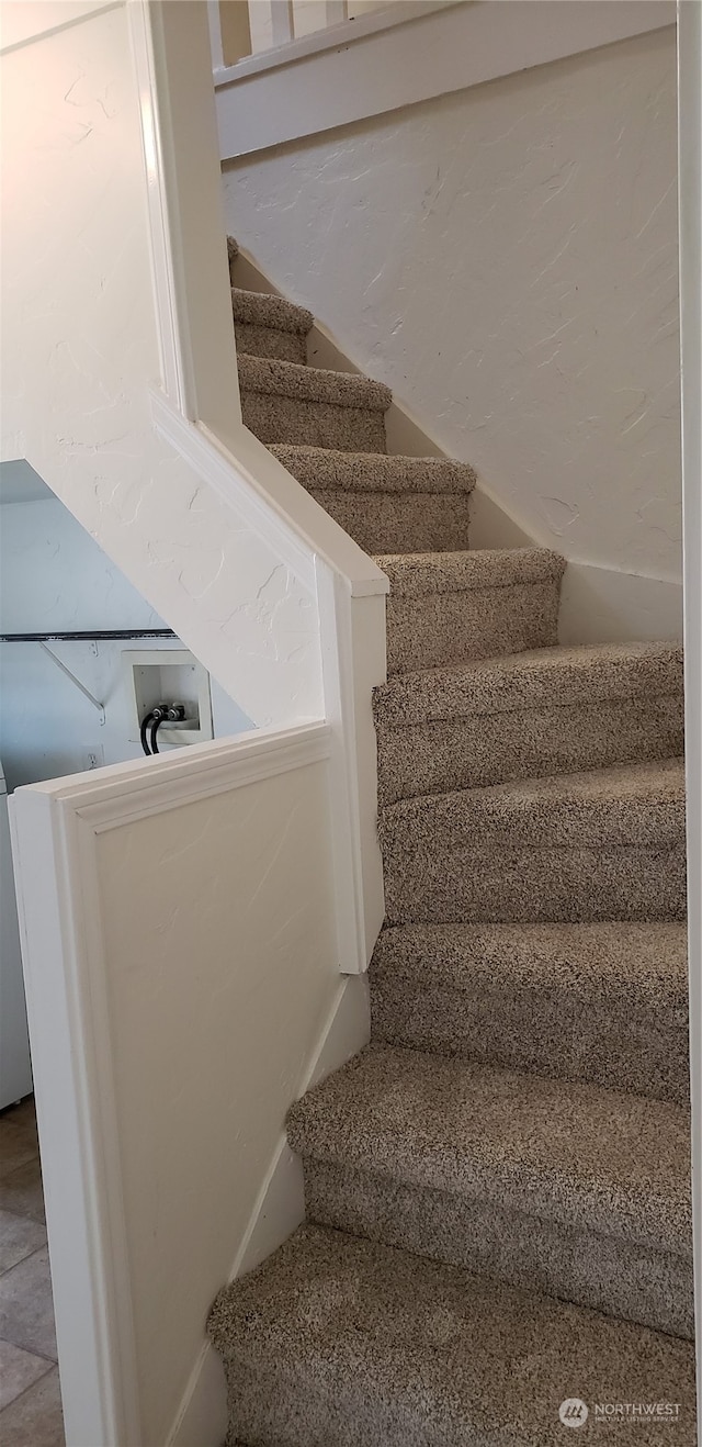 staircase featuring tile patterned flooring