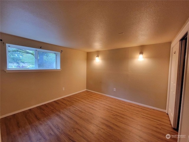 13808 C St S, Tacoma, WA 98444 - empty room featuring a textured ceiling, wood finished floors, and baseboards