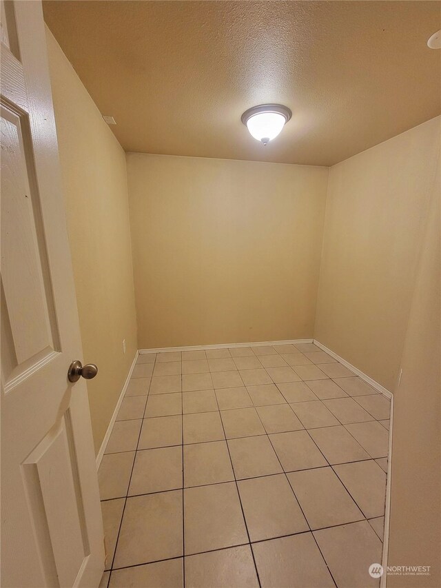 13808 C St S, Tacoma, WA 98444 - empty room with a textured ceiling, light tile patterned flooring, and baseboards