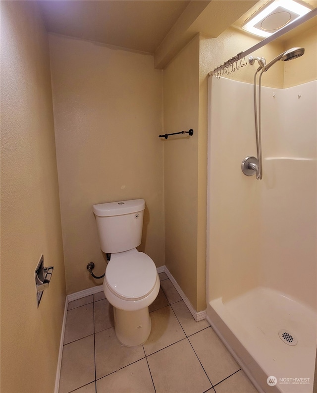 bathroom featuring tile patterned floors, a shower, and toilet