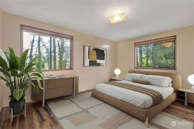 bedroom with multiple windows and wood-type flooring