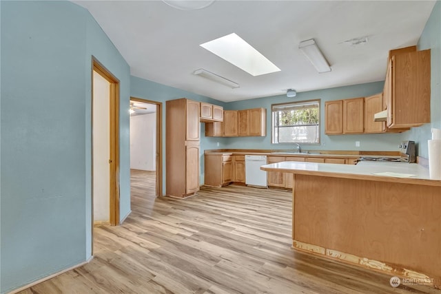 kitchen featuring sink, dishwasher, range, light brown cabinetry, and light wood-type flooring