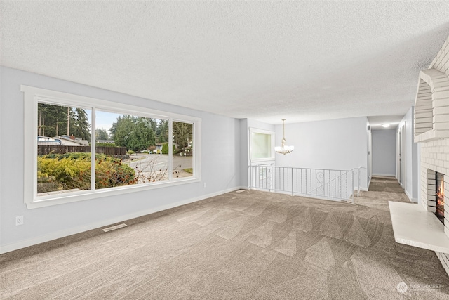 unfurnished living room featuring a fireplace, carpet, and a textured ceiling