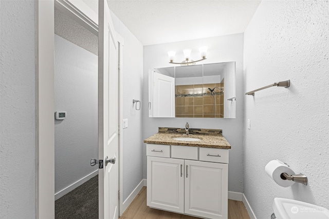 bathroom featuring hardwood / wood-style floors, vanity, and a textured ceiling