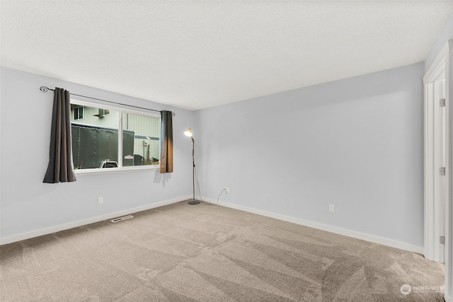 carpeted empty room with a textured ceiling