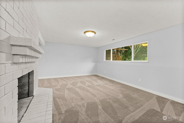 unfurnished living room featuring light carpet, a fireplace, and a textured ceiling