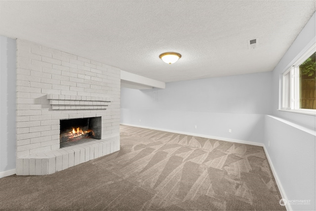 unfurnished living room featuring carpet, a textured ceiling, and a brick fireplace