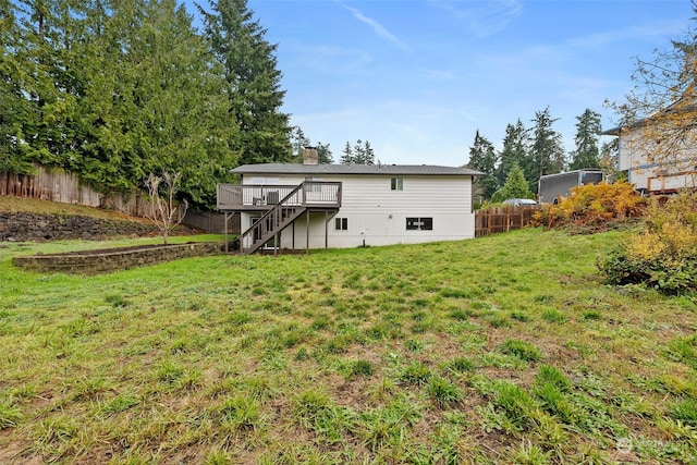 rear view of house featuring a lawn and a deck