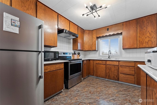 310 W 3rd Ave, Ritzville, WA 99169 - kitchen featuring stainless steel appliances, range hood, a sink, brown cabinetry, and decorative backsplash