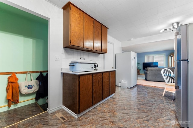 310 W 3rd Ave, Ritzville, WA 99169 - kitchen with freestanding refrigerator, decorative backsplash, open floor plan, and light countertops