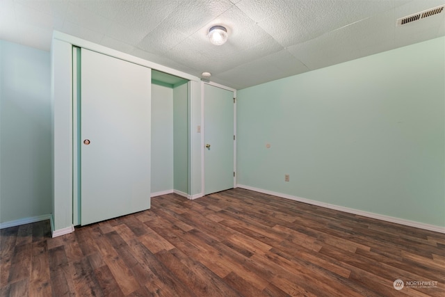 unfurnished bedroom featuring dark hardwood / wood-style floors and a closet