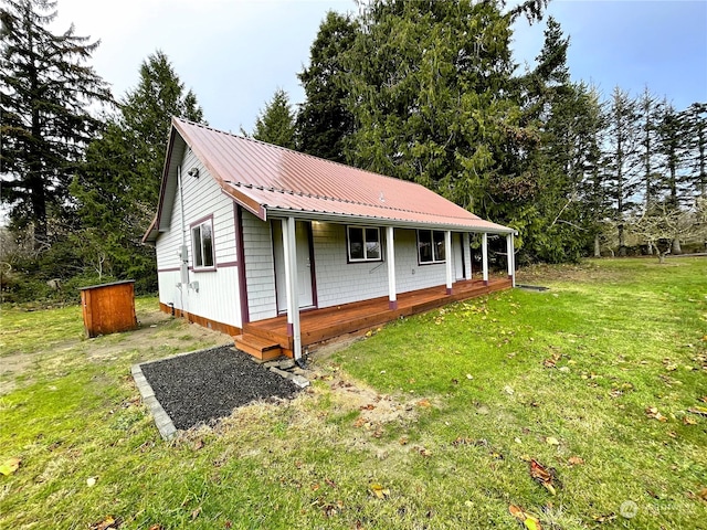 view of property exterior with metal roof and a yard