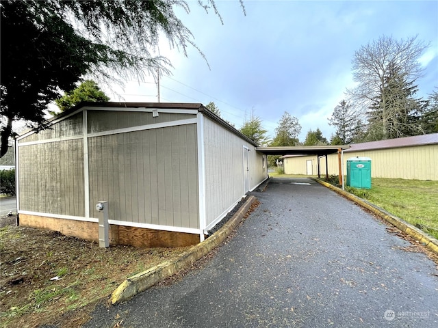 view of side of home featuring driveway and an attached carport