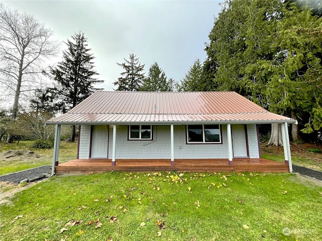 view of front of property featuring metal roof and a front yard