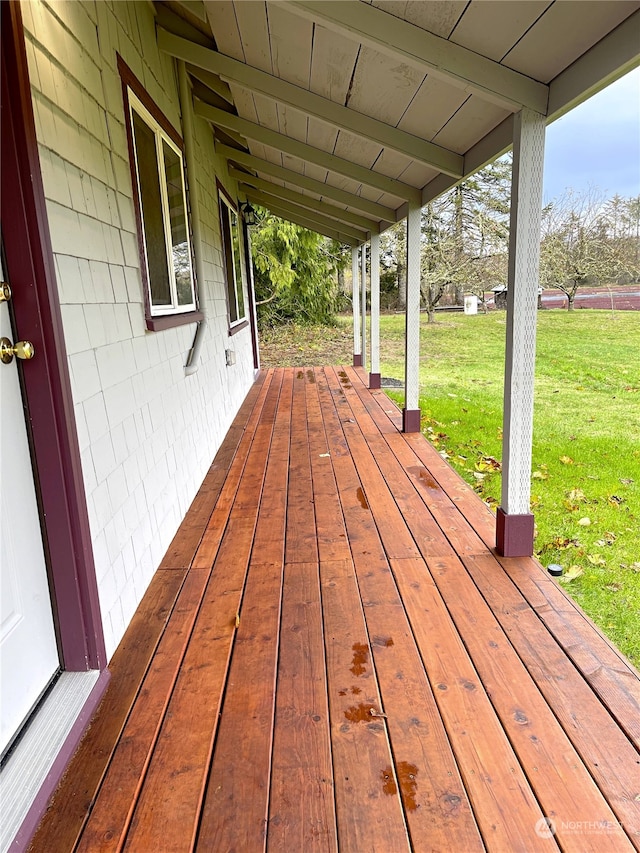 wooden terrace featuring a yard