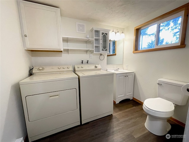 laundry area featuring a textured ceiling, laundry area, baseboards, dark wood-style floors, and washer and clothes dryer